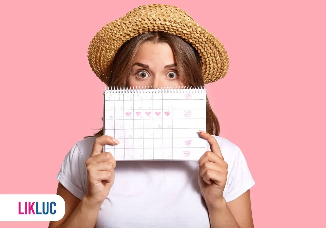 mulher de chapeu de palha sergurando calendario nas maos cobrindo parte do rosto com olhar de surpresa