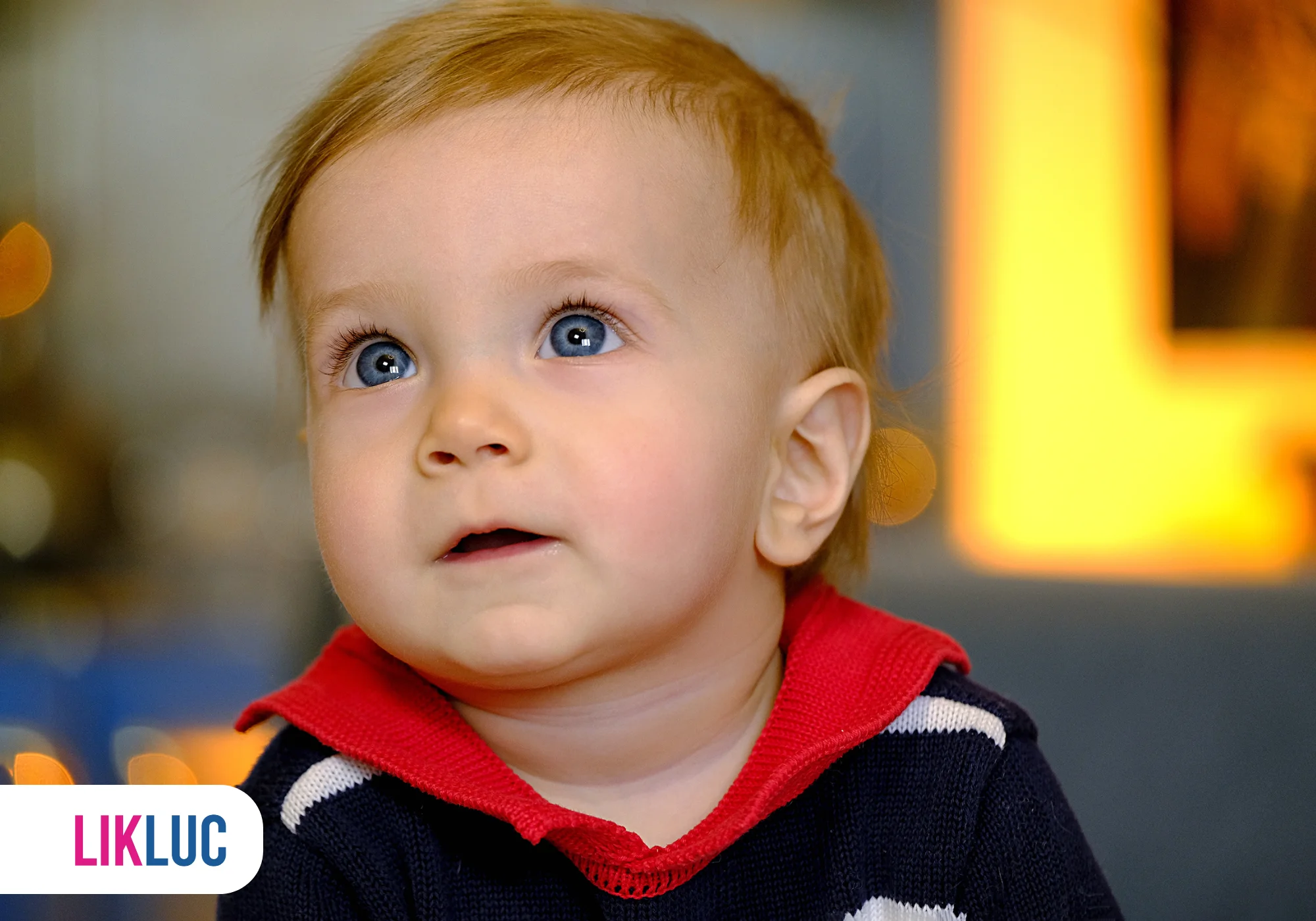 Bebê curioso olhando para cima com olhos azuis