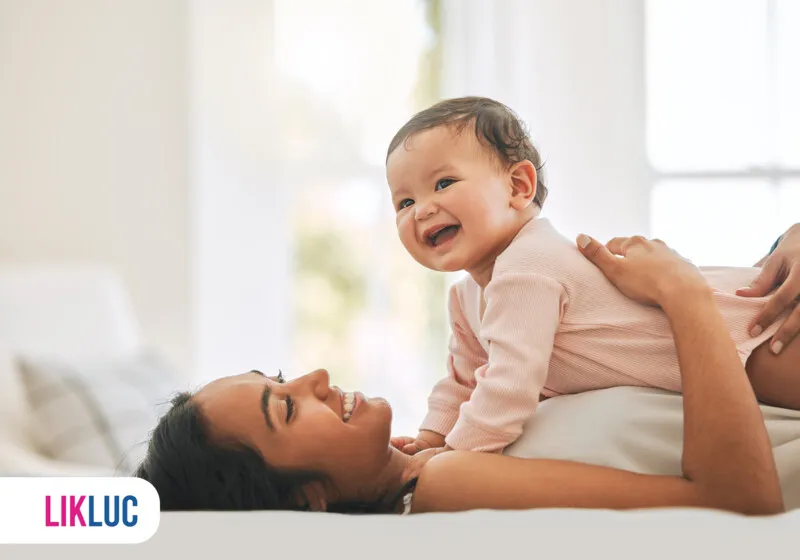Mãe brincando com bebê em casa, ambiente aconchegante