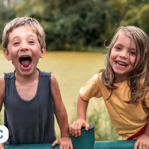 Crianças sorrindo em um parque ao ar livre
