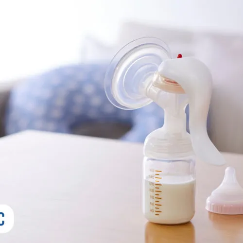 Bombinha de leite materno sobre mesa de madeira